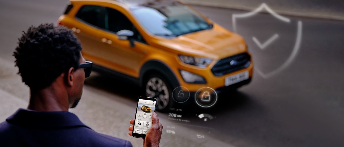 Man with phone checking app in mobile near Ford EcoSport