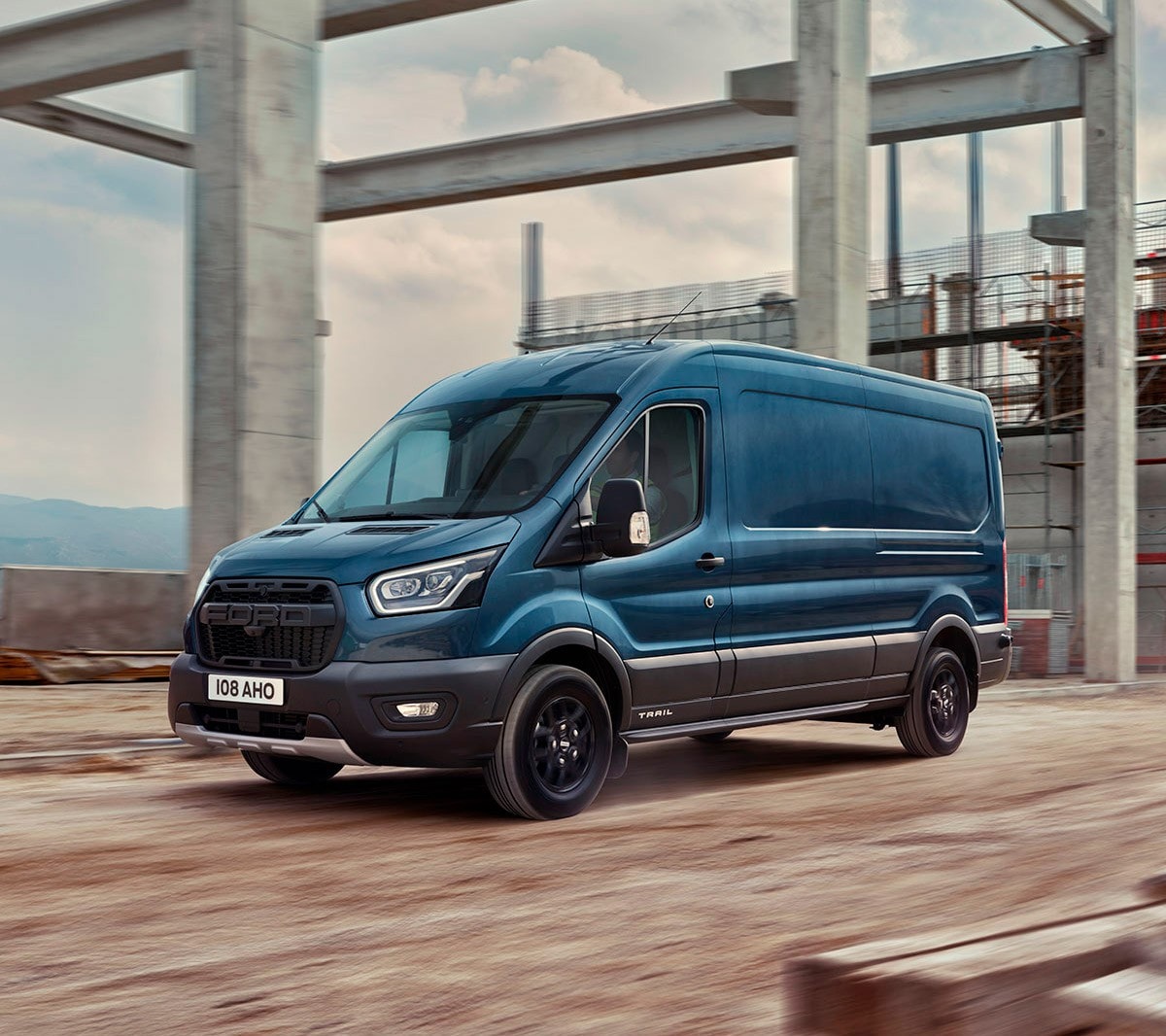 Blue Ford Transit Van driving at a building site