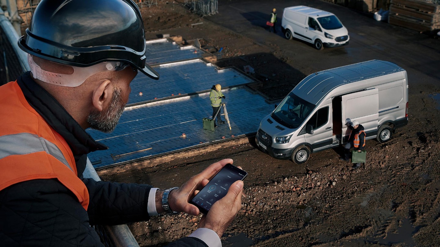 man in high viz jacket in building site looking at his mobile phone with FordPass Pro 