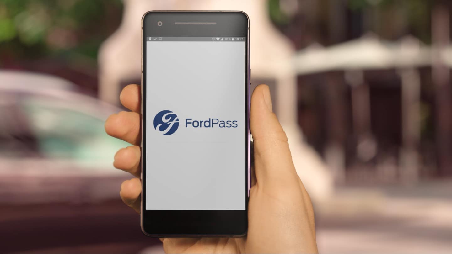 Hand holding a mobile phone with FordPass application