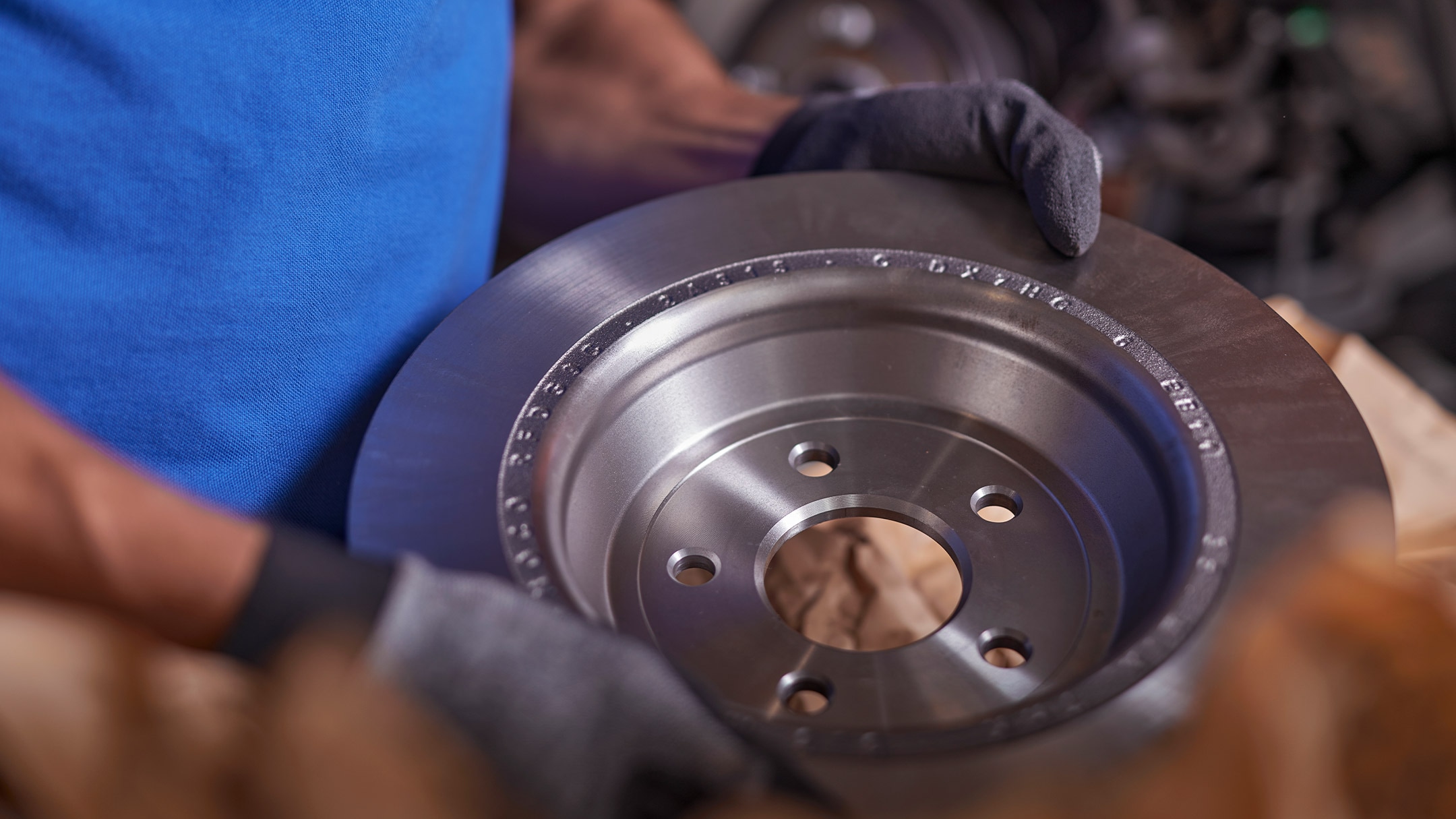 Mechanik trzyma oryginalną część Forda podczas serwisu i naprawy.
