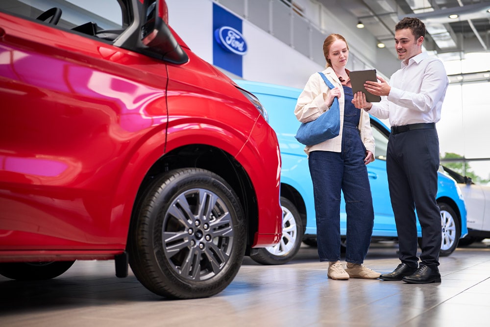 Samochód dostawczy Ford zaparkowany przed salonem