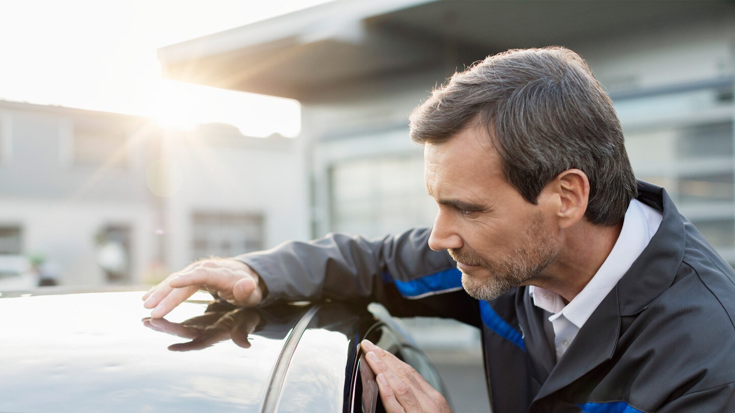 Man inspecting roof of Ford vehicle