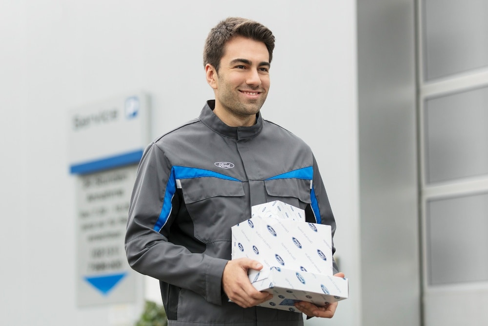 Mechanik serwisu Forda trzymający oryginalne części