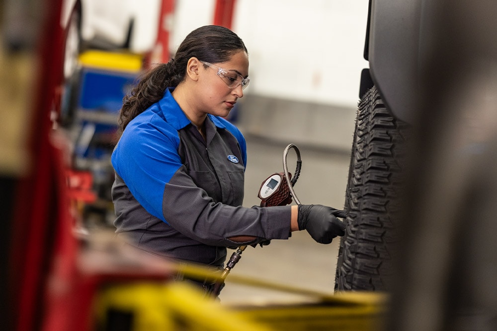Technik serwisu Ford dokręcający śruby koła