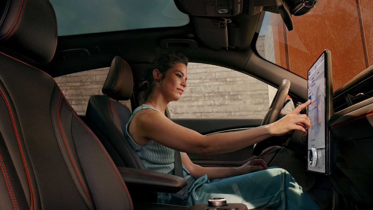 Woman using the central touchscreen in her Ford Woman using the central touchscreen in her Ford