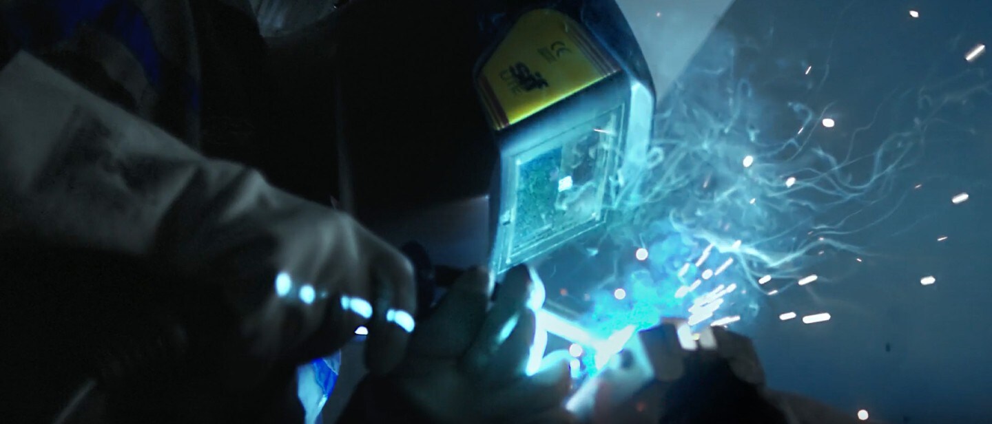 A team of Ford technicians walk through a Ford service workshop.